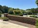 Landscaped community entrance featuring a brick wall with trees and shrubs at 125 Villa Park Cir, Stone Mountain, GA 30087