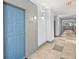 An inviting hallway entrance features a blue entry door with neutral tile flooring and ample lighting at 400 17Th Nw St # 1253, Atlanta, GA 30318