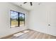 Bright bedroom with a large window, modern ceiling fan, and light hardwood floors at 532 Rockbridge Rd, Lilburn, GA 30047
