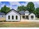 Beautiful modern farmhouse with white siding, black trim, and a well-manicured lawn at 532 Rockbridge Rd, Lilburn, GA 30047