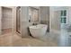 Modern bathroom with a standalone tub and separate glass-enclosed shower and backyard door access at 297 Delta Dr, Mcdonough, GA 30252