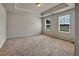 Spacious bedroom with plush carpet, tray ceiling, and plenty of natural light at 297 Delta Dr, Mcdonough, GA 30252