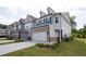 New construction townhome exterior with brick accents, attached garage, landscaping, and neutral color palette at 668 Isom Walk, Suwanee, GA 30024