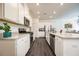 Well-lit kitchen with white cabinets, stainless steel appliances, granite countertops, and wood floors at 668 Isom Walk, Suwanee, GA 30024