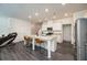 Open kitchen featuring a granite island, stainless steel appliances, white cabinetry, and pendant lighting at 668 Isom Walk, Suwanee, GA 30024