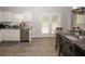 Well-lit dining area with a wooden table for six, adjacent to the kitchen and an exterior door at 1000 Willow Crest Lndg, Austell, GA 30168