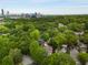 Bird's eye view of a home nestled in a green, lush canopy with the city skyline in the background at 1020 Austin Ne Ave, Atlanta, GA 30307
