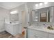 Bright bathroom featuring double sinks, quartz countertops, modern mirrors and fixtures, with tile floors at 1020 Austin Ne Ave, Atlanta, GA 30307