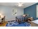Cozy bedroom showcasing blue accent wall, hardwood floors, window with shutters and natural light at 1020 Austin Ne Ave, Atlanta, GA 30307
