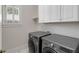 Convenient laundry room with front load washer and dryer and white cabinets above at 1020 Austin Ne Ave, Atlanta, GA 30307