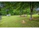 Expansive backyard with lush green grass, mature trees, and a glimpse of a fence and trailer at 1565 Wynfield Dr, Auburn, GA 30011