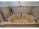 Elegant bathroom featuring a modern jetted tub with tiled accents and fixtures at 1565 Wynfield Dr, Auburn, GA 30011