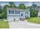 Inviting two-story home with a two-car garage, a blue front door wreath and well-kept lawn at 1565 Wynfield Dr, Auburn, GA 30011