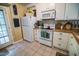 Well-lit kitchen featuring white appliances, tile floors, and a convenient side door at 1565 Wynfield Dr, Auburn, GA 30011