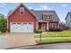 Charming two-story home features a two-car garage, landscaped yard, and patriotic American flag at 161 Overlook Cir, Canton, GA 30115