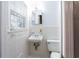 Cozy bathroom with white tile, a pedestal sink, toilet, and a sunny window at 2620 Clairmont Rd, Atlanta, GA 30329