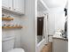 Cozy bathroom featuring a tub-shower combo, white fixtures, and built-in shelving for storage at 2620 Clairmont Rd, Atlanta, GA 30329