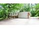 View of home exterior with brick facade, white siding and two-car garage surrounded by mature trees and a long drive at 2620 Clairmont Rd, Atlanta, GA 30329