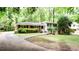 View of a charming home exterior with brick, white siding, and a lush front yard, surrounded by mature trees at 2620 Clairmont Rd, Atlanta, GA 30329