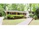 View of home exterior featuring a well-manicured lawn, brick facade, black shutters, and white siding at 2620 Clairmont Rd, Atlanta, GA 30329