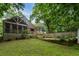 View of the home's backyard with a screened-in porch, wooden deck, green grass, and a wooden privacy fence at 978 Eden Se Ave, Atlanta, GA 30316