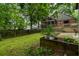 A beautiful backyard with green grass, a wooden privacy fence, mature trees, and a screened-in porch at 978 Eden Se Ave, Atlanta, GA 30316