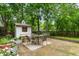 Backyard concrete patio with dining set and potted plants, under the shade of mature trees at 978 Eden Se Ave, Atlanta, GA 30316
