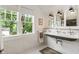 Bright bathroom featuring tiled floors, a tiled shower, a unique vintage sink, and a large window at 978 Eden Se Ave, Atlanta, GA 30316