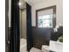 Bathroom featuring tiled shower, wainscoting, and a window with black trim at 978 Eden Se Ave, Atlanta, GA 30316