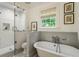 Bright bathroom featuring a standalone tub, glass shower, and classic tile flooring at 978 Eden Se Ave, Atlanta, GA 30316