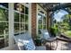 Sunlit front porch with cozy seating, framed by bright white windows and green foliage at 978 Eden Se Ave, Atlanta, GA 30316