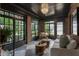 Stylish sunroom boasts exposed brick, dark trim, checkerboard floors, and sun-drenched windows at 978 Eden Se Ave, Atlanta, GA 30316