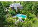 Stunning aerial view of a large home with a pool and lush landscaping surrounded by mature trees at 11569 Finley St, Suwanee, GA 30024