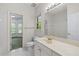 Bright bathroom with a large mirror, white tiled floor, and a white vanity at 11569 Finley St, Suwanee, GA 30024