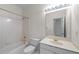 Well-lit bathroom with a tub and shower combination, a toilet, and a vanity at 11569 Finley St, Suwanee, GA 30024