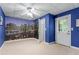 Large bedroom with cityscape mural, door to the exterior, and neutral carpet flooring at 11569 Finley St, Suwanee, GA 30024