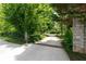 Long driveway with stone pillar entrance leads to a beautiful home surrounded by lush greenery at 11569 Finley St, Suwanee, GA 30024