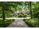 Beautiful brick home nestled among mature trees with a long, winding driveway at 11569 Finley St, Suwanee, GA 30024