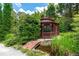 Backyard gazebo with landscaping and a small bridge over a pond is a charming addition at 11569 Finley St, Suwanee, GA 30024