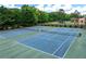 Outdoor tennis courts featuring pristine blue courts, green surroundings, and a tall green border at 11569 Finley St, Suwanee, GA 30024