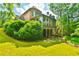 Expansive backyard showcasing a screened-in porch, stairs to the yard, and a private wooded backdrop at 2111 Broadfield Run, Duluth, GA 30097