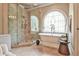 Bright bathroom featuring a soaking tub with a large window and a separate glass-enclosed shower with multiple shower heads at 2111 Broadfield Run, Duluth, GA 30097