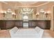 Luxurious bathroom with and vanities, granite countertop, decorative mirrors and lighting, and a central seating area at 2111 Broadfield Run, Duluth, GA 30097