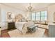 Inviting bedroom features a decorative chandelier, a seating area, and natural light at 2111 Broadfield Run, Duluth, GA 30097