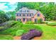 Charming two-story brick home with manicured landscaping, lush green lawn, and mature trees at 2111 Broadfield Run, Duluth, GA 30097