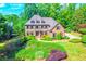 Charming two-story brick home with manicured landscaping, lush green lawn, and mature trees at 2111 Broadfield Run, Duluth, GA 30097