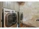 Updated laundry room features grey cabinets and stainless steel washer and dryer at 2111 Broadfield Run, Duluth, GA 30097