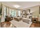 Comfortable living room featuring hardwood floors, a large sofa, and large windows at 2111 Broadfield Run, Duluth, GA 30097