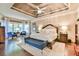 Spacious main bedroom with tray ceiling, king-size bed, sitting area, and hardwood floors at 2111 Broadfield Run, Duluth, GA 30097