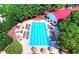 Aerial view of a large outdoor swimming pool with lounge chairs and umbrellas surrounded by trees at 2111 Broadfield Run, Duluth, GA 30097